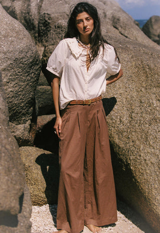  wearing a loose white blouse with lace trim