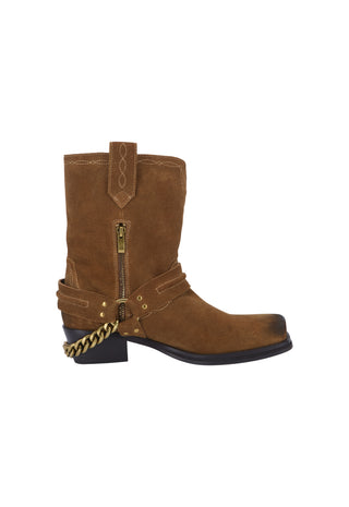 A brown suede western-style ankle boot with a side zipper, decorative strap with brass studs, and a gold chain detail on the heel, shown against a plain white background.