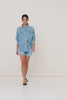 Model, Michelle Bagarra, wearing Spell Classic Chambray Shirt. The long-sleeved, front button-down shirt is made of denim and features two pockets and a collar.